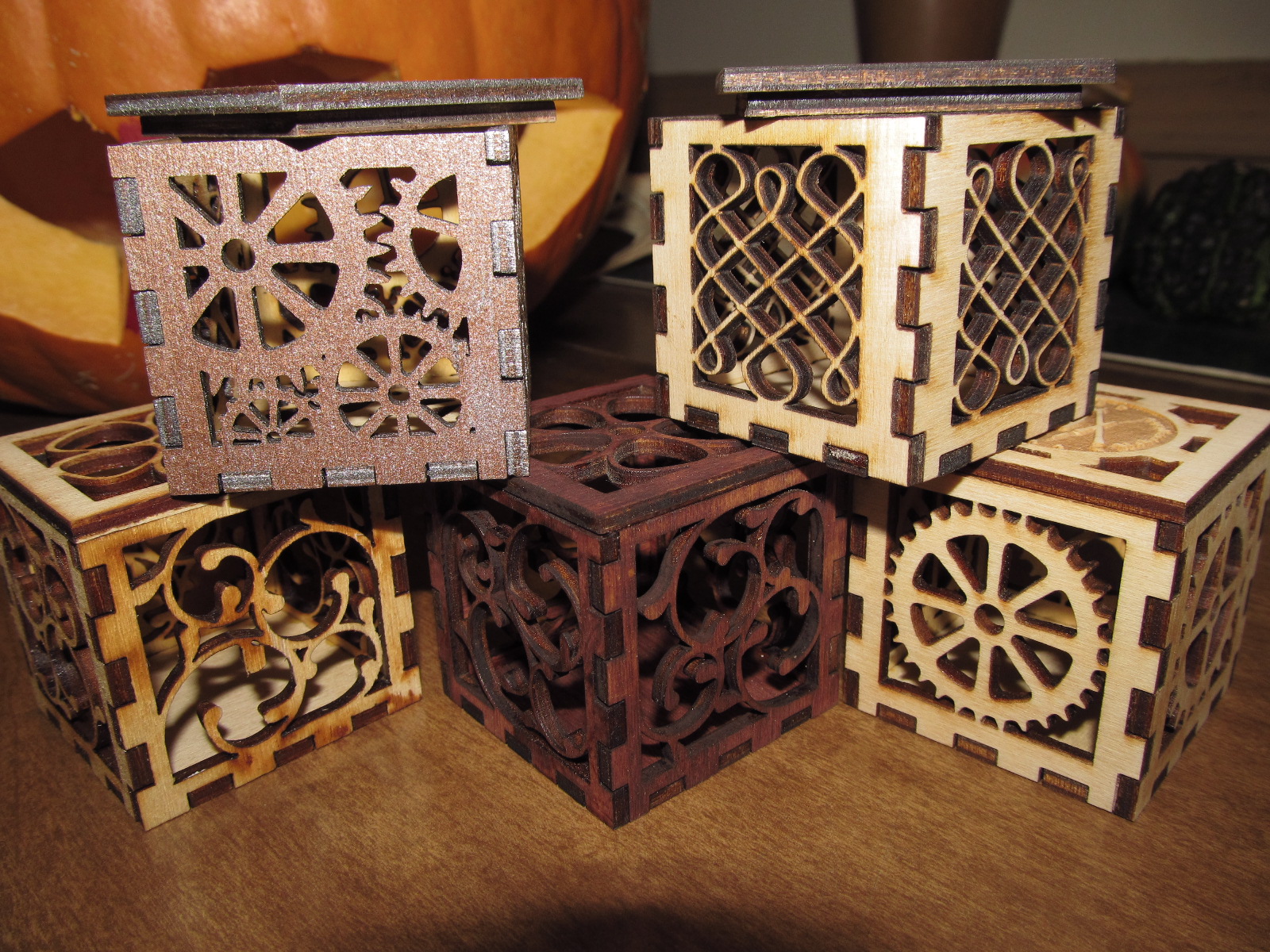 A family of 5 two-inch square wooden boxes featuring gears, vines and Celtic knots